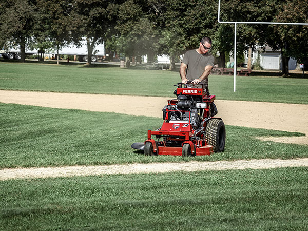 Man riding stand on commercial mower